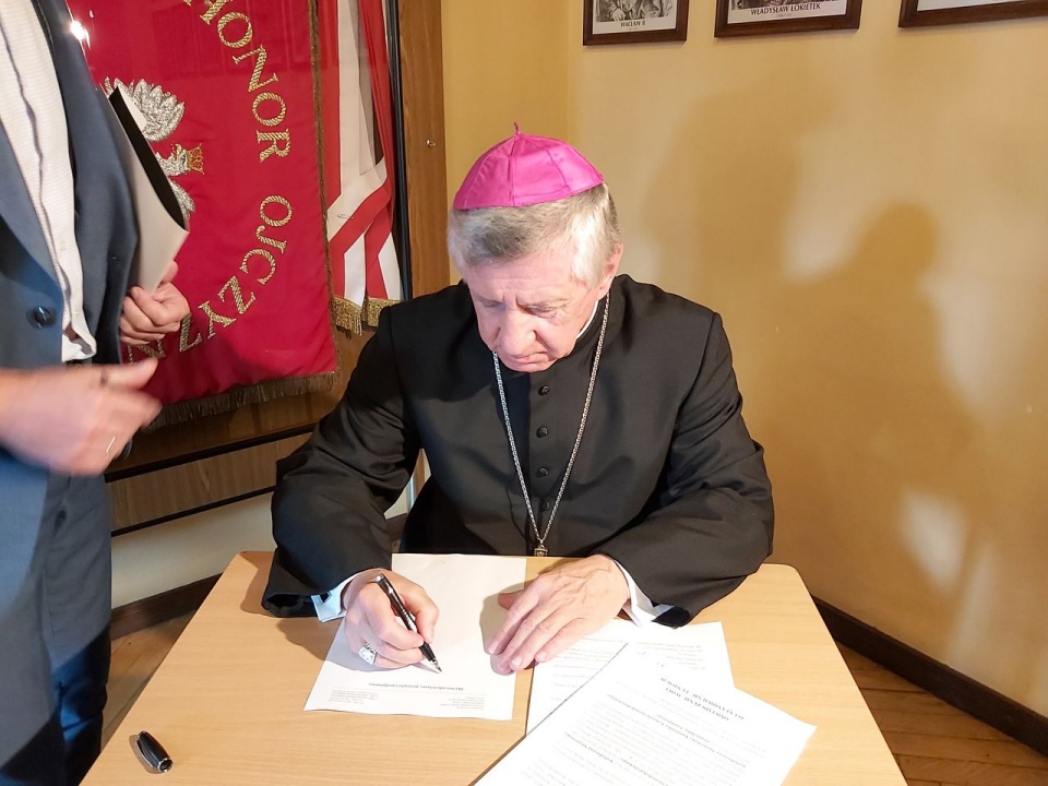 Ks. Arybiskup Andrzej Dzięga podpisuje akt założycielski Fundacji księdza Wojtka. [fot