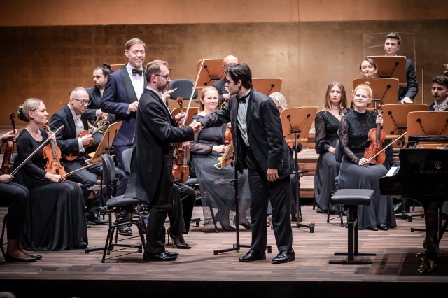 David Khrikuli – pianista (od prawej) dziękuje Pawłowi Maślance – koncertmistrzowi Orkiestry Symfonicznej Filharmonii im. Mieczysława Karłowicza w Szczecinie za wspólny występ. Fot. Michał Grocholski David Khrikuli wirtuozowskim popisem otworzył 79. sezon Filharmonii w Szczecinie [POSŁUCHAJ, ZDJĘCIA]