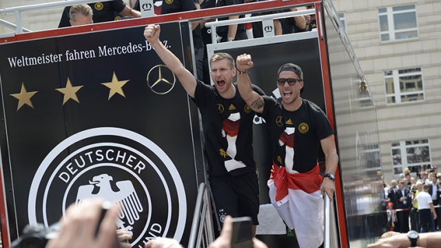 Z prawej napastnik Łukasz Podolski z polską flagą narodową. Fot. Tomasz Chaciński [Radio Szczecin] Piłkarze już w domu. Berlin wita mistrzów świata [WIDEO, DUŻO ZDJĘĆ]