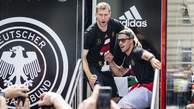 Z prawej napastnik Łukasz Podolski z polską flagą narodową. Fot. Tomasz Chaciński [Radio Szczecin] Piłkarze już w domu. Berlin wita mistrzów świata [WIDEO, DUŻO ZDJĘĆ]