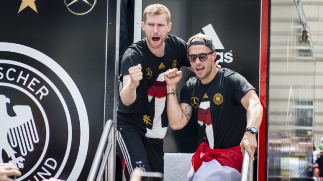Z prawej napastnik Łukasz Podolski z polską flagą narodową. Fot. Tomasz Chaciński [Radio Szczecin] Piłkarze już w domu. Berlin wita mistrzów świata [WIDEO, DUŻO ZDJĘĆ]