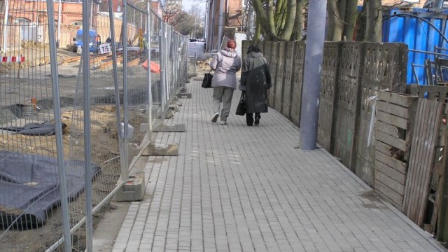 Wykonawca prac po jednej stronie ulicy kończy już układanie chodnika.