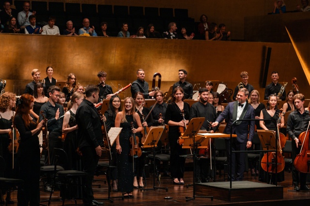 Monika Sawczuk – skrzypaczka (uśmiechnięta na środku zdjęcia) przyjmuje gorące brawa publiczności. Fot. Piotr Makowski Finał 12. International Lutosławski Youth Orchestra w Złotej Sali Filharmonii [ZDJĘCIA]