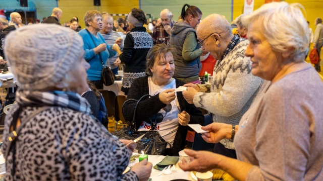 Wigilijne potrawy, paczki żywnościowe i wspólne dzielenie się opłatkiem przy tradycyjnych polskich kolędach.