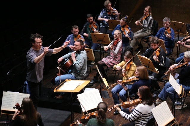 Sergey Simakov dyryguje wiolonczelistą Tomaszem Darochem i Orkiestrą Symfoniczną Filharmonii w Szczecinie na próbie generalnej przed koncertem (21 lutego 2025). Fot. Leszek Konicki Wiolonczelista Tomasz Daroch zaprasza w środku karnawału do Filharmonii [ZDJĘCIA]
