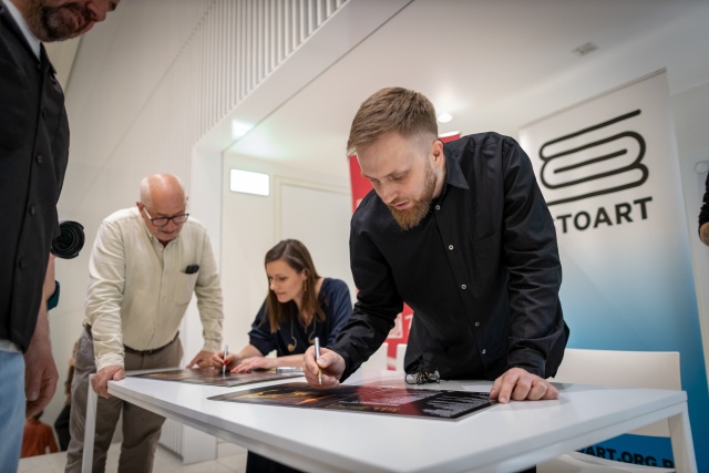 Nikola Kołodziejczyk składa autografy na okładce albumu pt. „Budyń o smaku Mickiewicza”. Fot. Sebastian Wołosz „Budyń o smaku Mickiewicza” podano w złocie Filharmonii [ZDJĘCIA]
