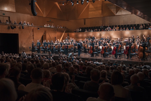 Przemysław Neumann – dyrygent przyjmuje owacyjne brawa publiczności z International Lutosławski Youth Orchestra 2025. Fot. Piotr Nykowski Owacyjne przyjęcie Aleksandry Świgut i orkiestry ILYO 2025 w Filharmonii [ZDJĘCIA]