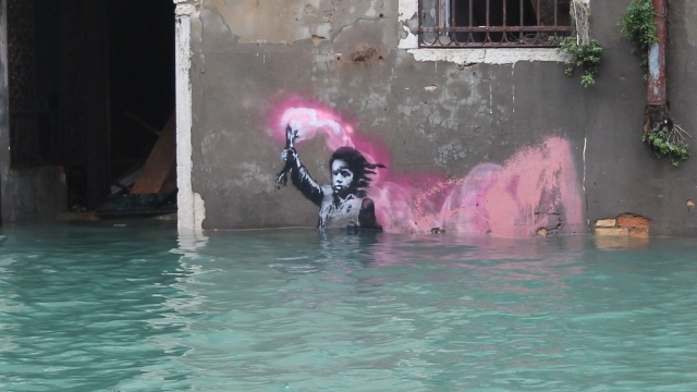 Słynny mural Banksyego Dziecko-migrant na fasadzie pałacu w Wenecji, wraz z częścią ściany na której został namalowany, został przewieziony do renowacji. Woda zniszczyła jedną trzecią pracy.