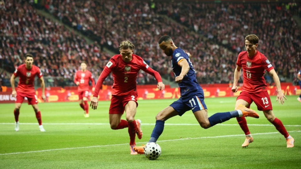 Polacy Matty Cash i Jakub Kamiński oraz Cody Gakpo z Holandii podczas meczu eliminacyjnego piłkarskich mistrzostw świata. w Warszawie. PAP/Leszek Szymański