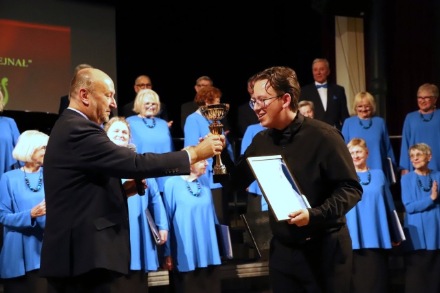 Prof. Dariusz Dyczewski (od lewej) wręcza Patrykowi Wróblewskiemu – dyrygentowi Chóru Hejnał Puchar Festiwalu w Międzyzdrojach. Fot. Tomasz Rychłowski Szczecińskie chóry górą na 61. Międzynarodowym Festiwalu im. prof. Jana Szyrockiego w Międzyzdrojach [ZDJĘCIA]